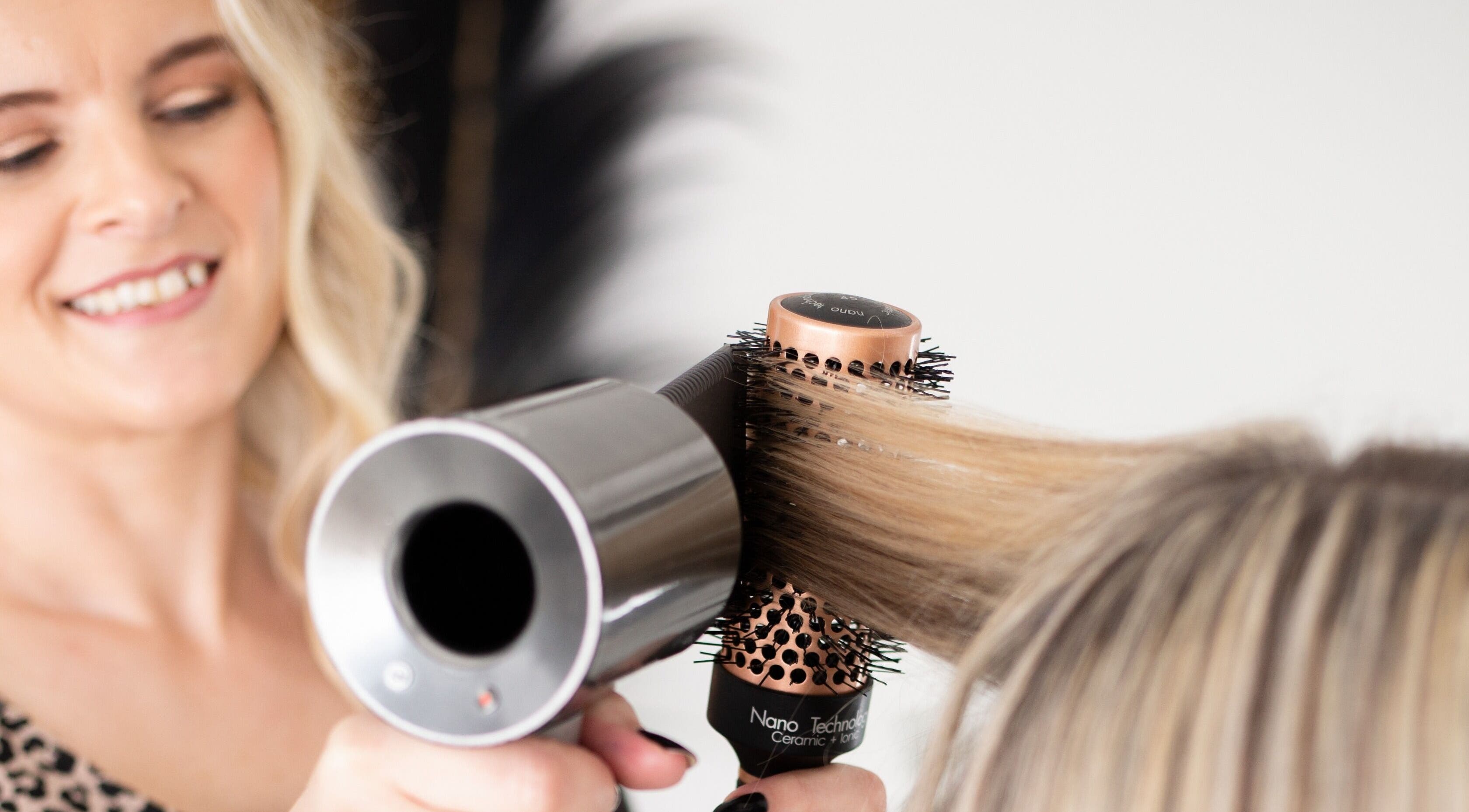 Stylist blow-dries hair at Loretta's Hair Spa in Papamoa, Bay Of Plenty, NZ, showcasing expert salon services.