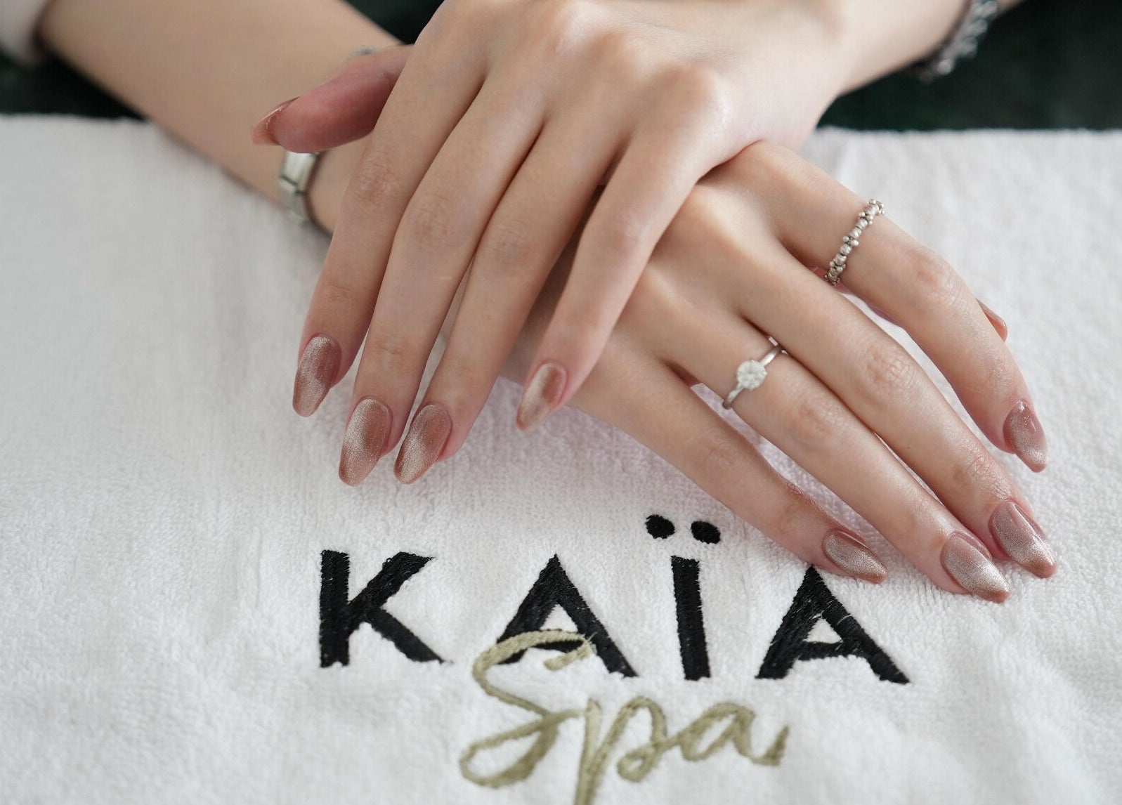 Stylish manicured hands at Kaia Spa - Ar Rayyan, Riyadh, Riyadh Province, SA, on a branded towel.