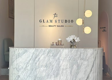 Reception area of The Glam Studio | ذا جلام ستوديو in Riyadh, with marble counter and chic decor.