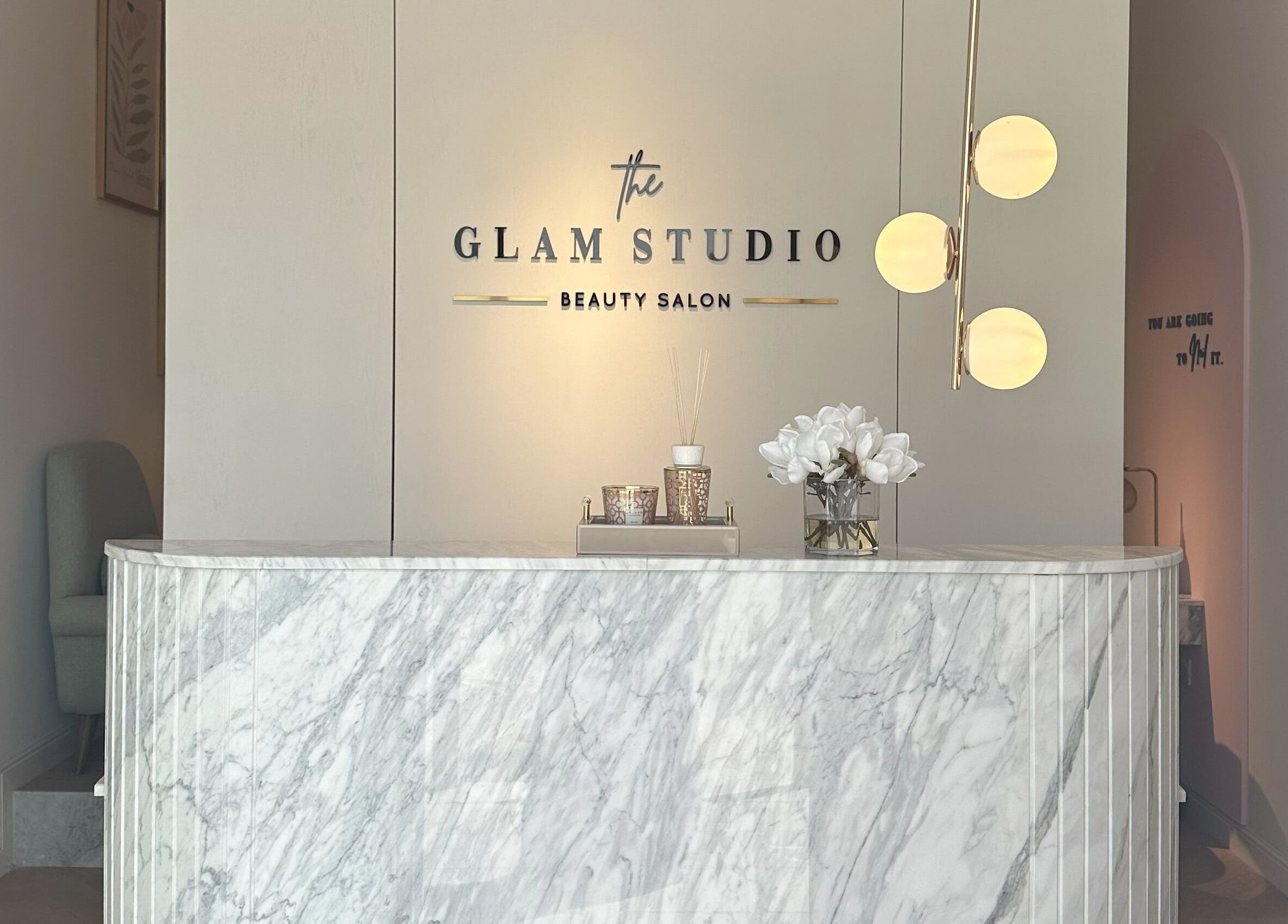 Reception area of The Glam Studio | ذا جلام ستوديو in Riyadh, with marble counter and chic decor.