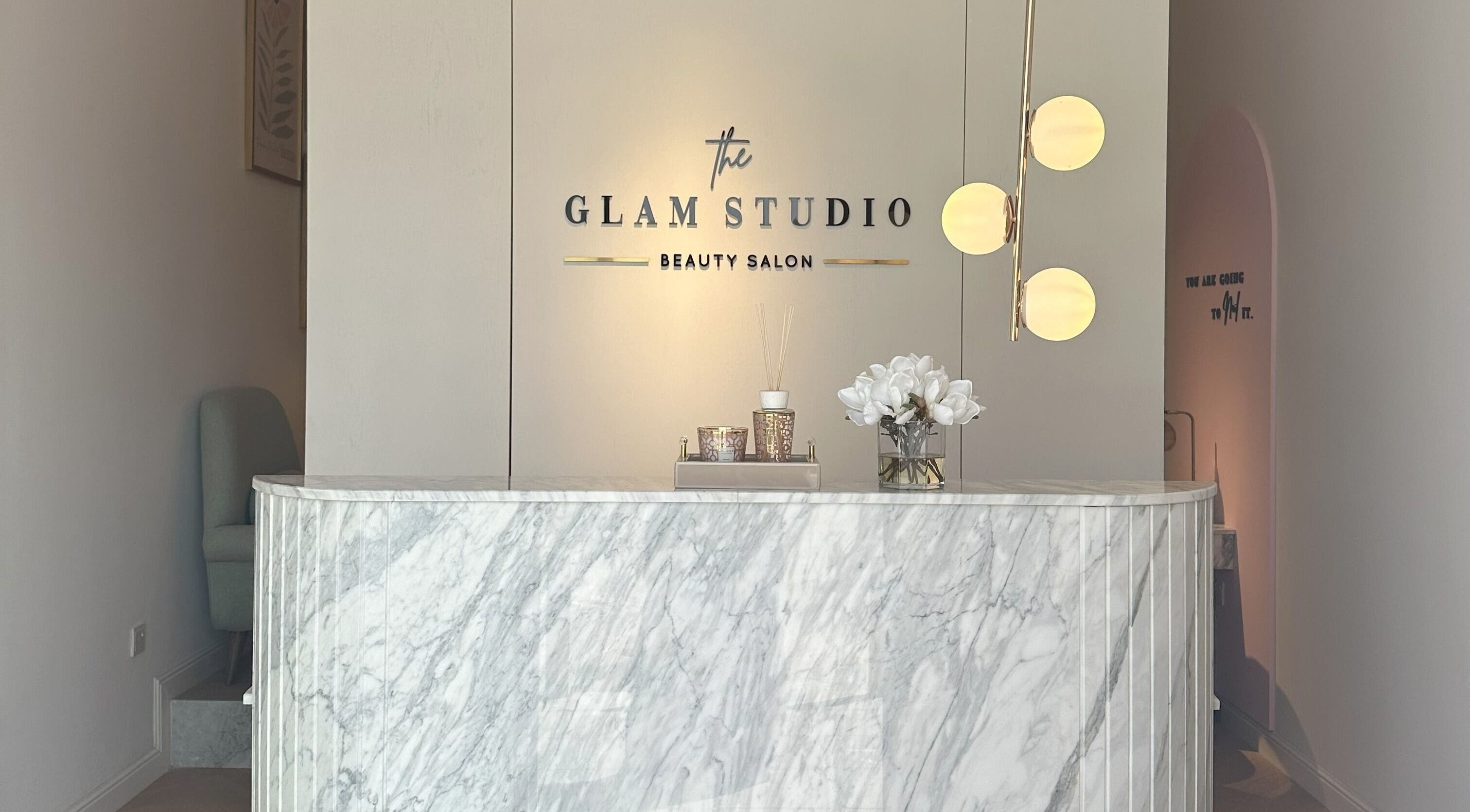 Reception area of The Glam Studio | ذا جلام ستوديو in Riyadh, with marble counter and chic decor.