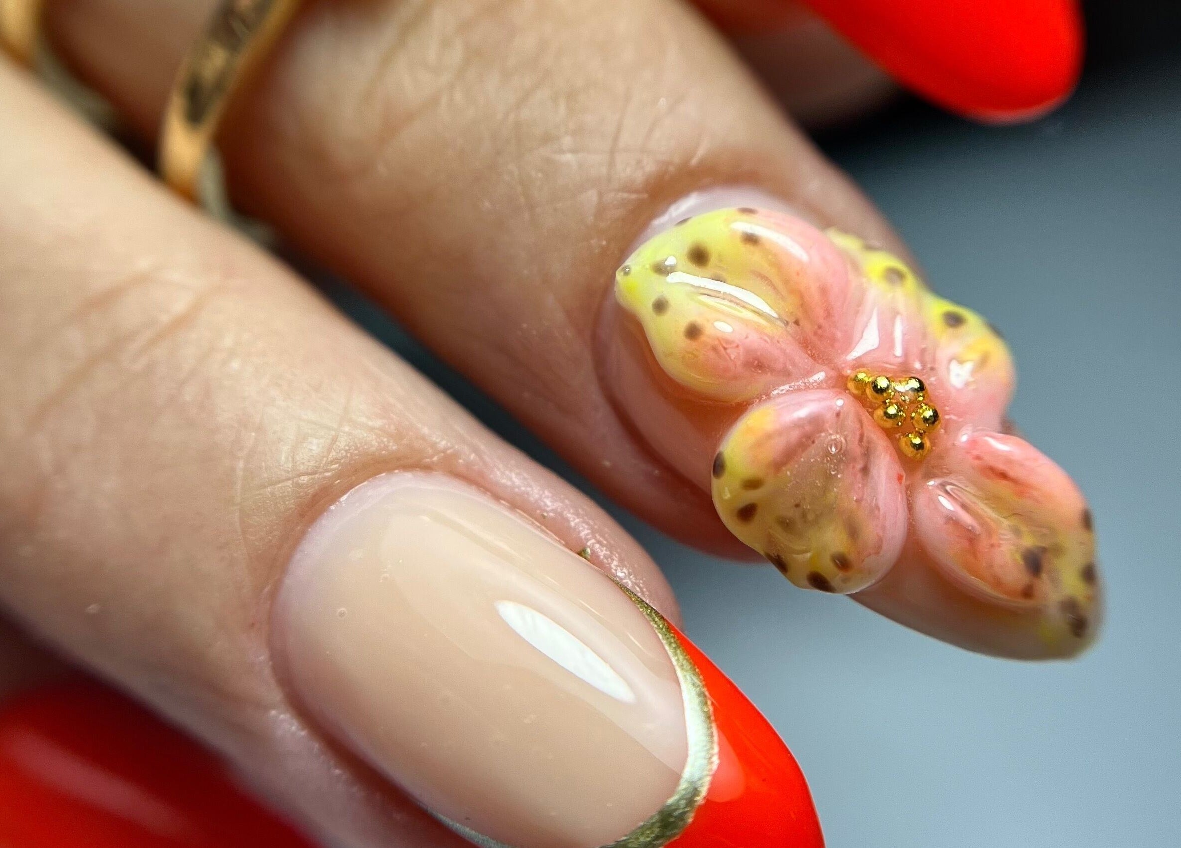 Цветен маникюр в VM Beauty Studio, София, София-град, BG, с 3D цветя на червен фон.