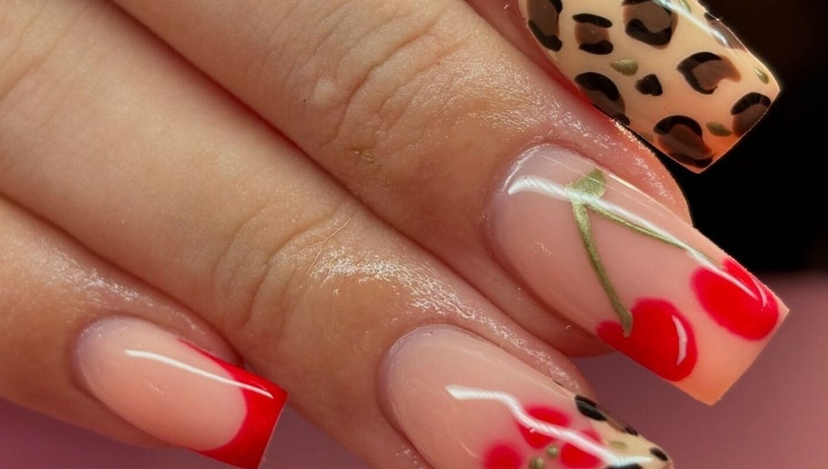 Stylish nail art at Beauty Duties, Rawreth, England, GB featuring red and leopard print designs.