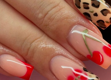 Stylish nail art at Beauty Duties, Rawreth, England, GB featuring red and leopard print designs.