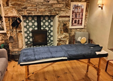 Holly Holmes Sports Massage venue in Falmouth, England, GB, with a massage table in a serene rustic room.