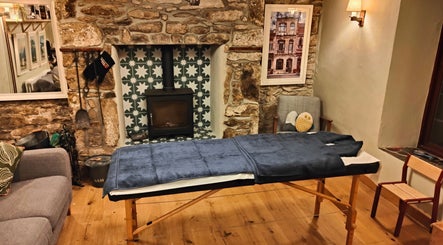 Holly Holmes Sports Massage venue in Falmouth, England, GB, with a massage table in a serene rustic room.