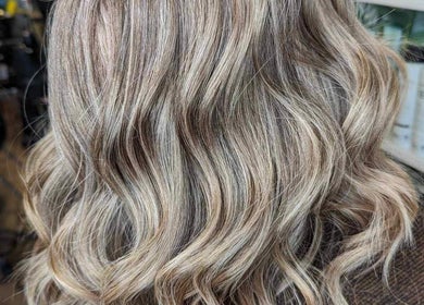 Elegant wavy hairstyle at Myrna Hastings Haair in Indian Head, Saskatchewan, CA, highlighting blonde highlights.