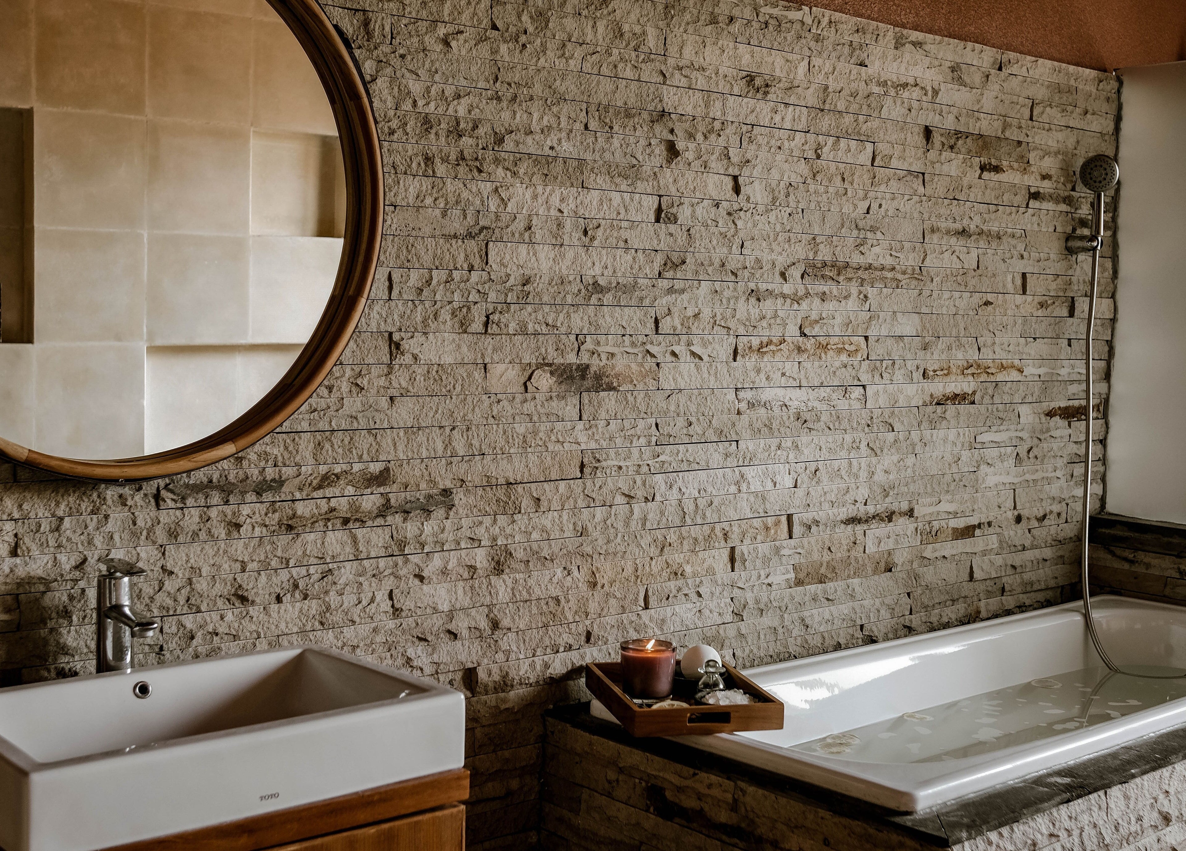 Elegant bathroom at Rituals Wellness Spa in Bali, Bali, ID, with rustic stone walls and modern fixtures.