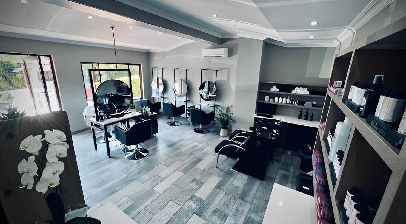 Modern salon interior at Mane Hair Studio, Pretoria, Gauteng, ZA with stylish seats and products displayed.