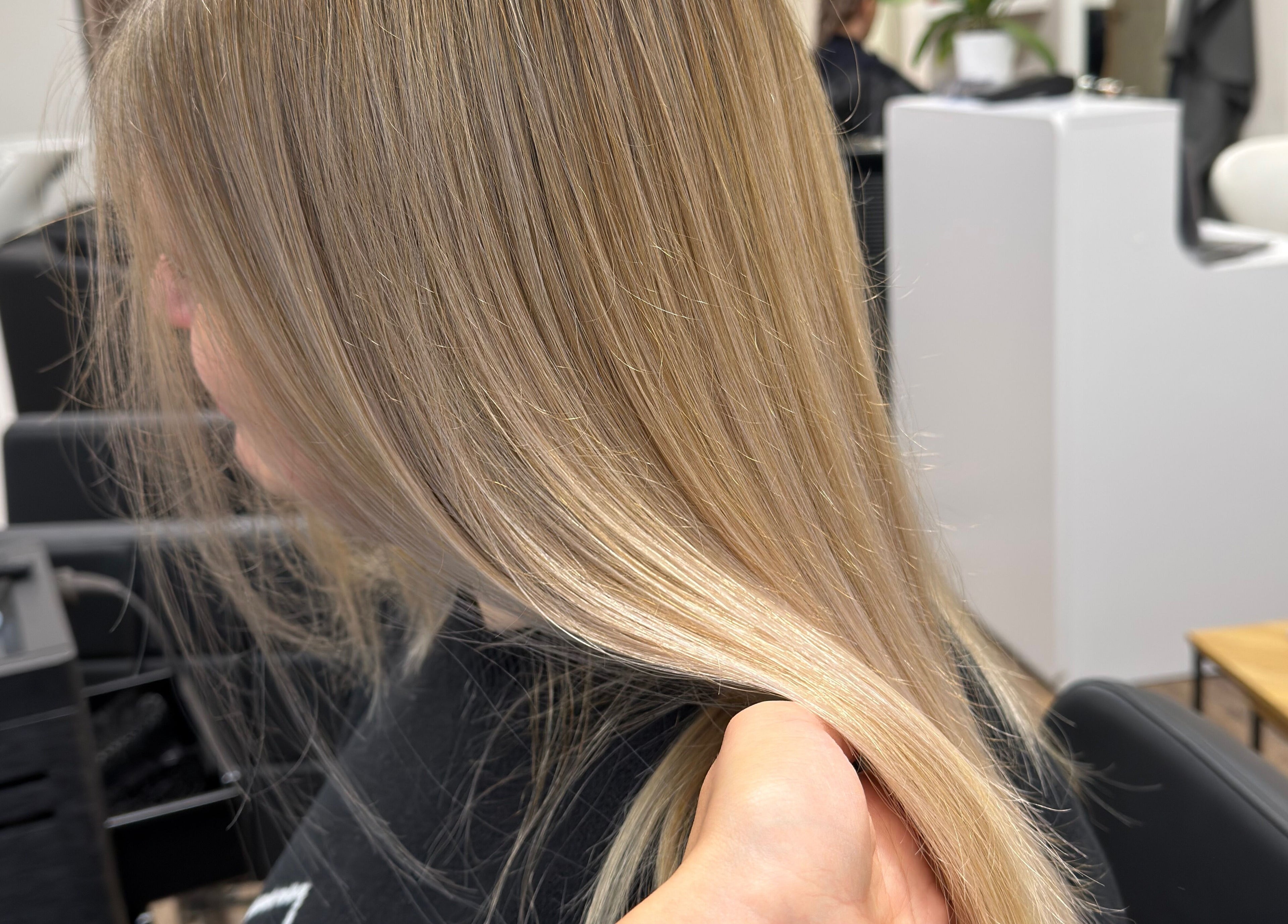 Blonde hair styled at Ulyana Azarova, Den Haag, Zuid-holland, NL, showcasing a smooth, silky finish.