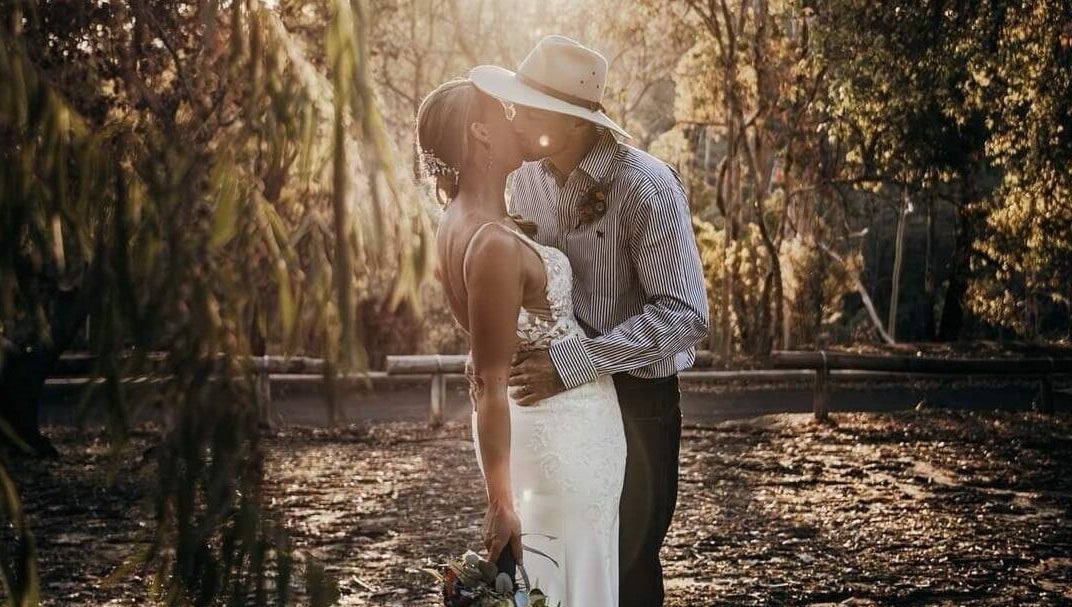 Couple embracing in a serene forest at Glow Tribe Spray Tanning, Glen Forrest, Western Australia, AU.