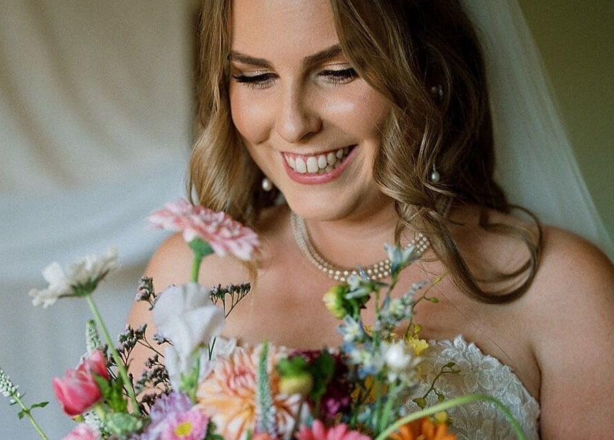 Smiling bride with bouquet at Glow Tribe Spray Tanning, Glen Forrest, Western Australia, AU.