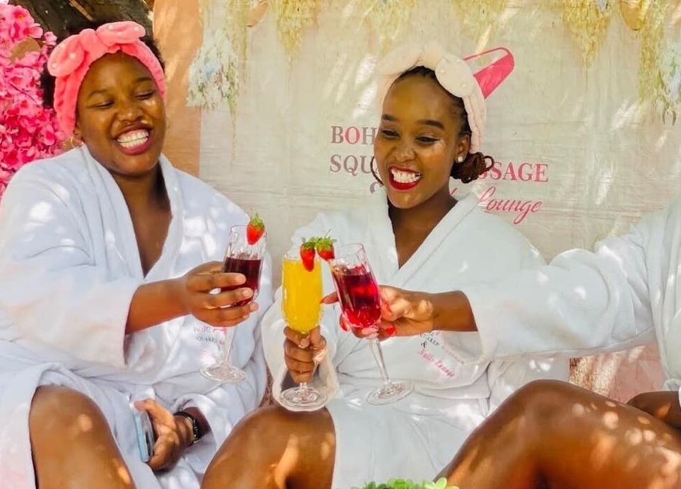 Women enjoying a refreshing spa day at Bohl Squared Beauty Spa, Springs, Gauteng, ZA, with pink flowers in view.