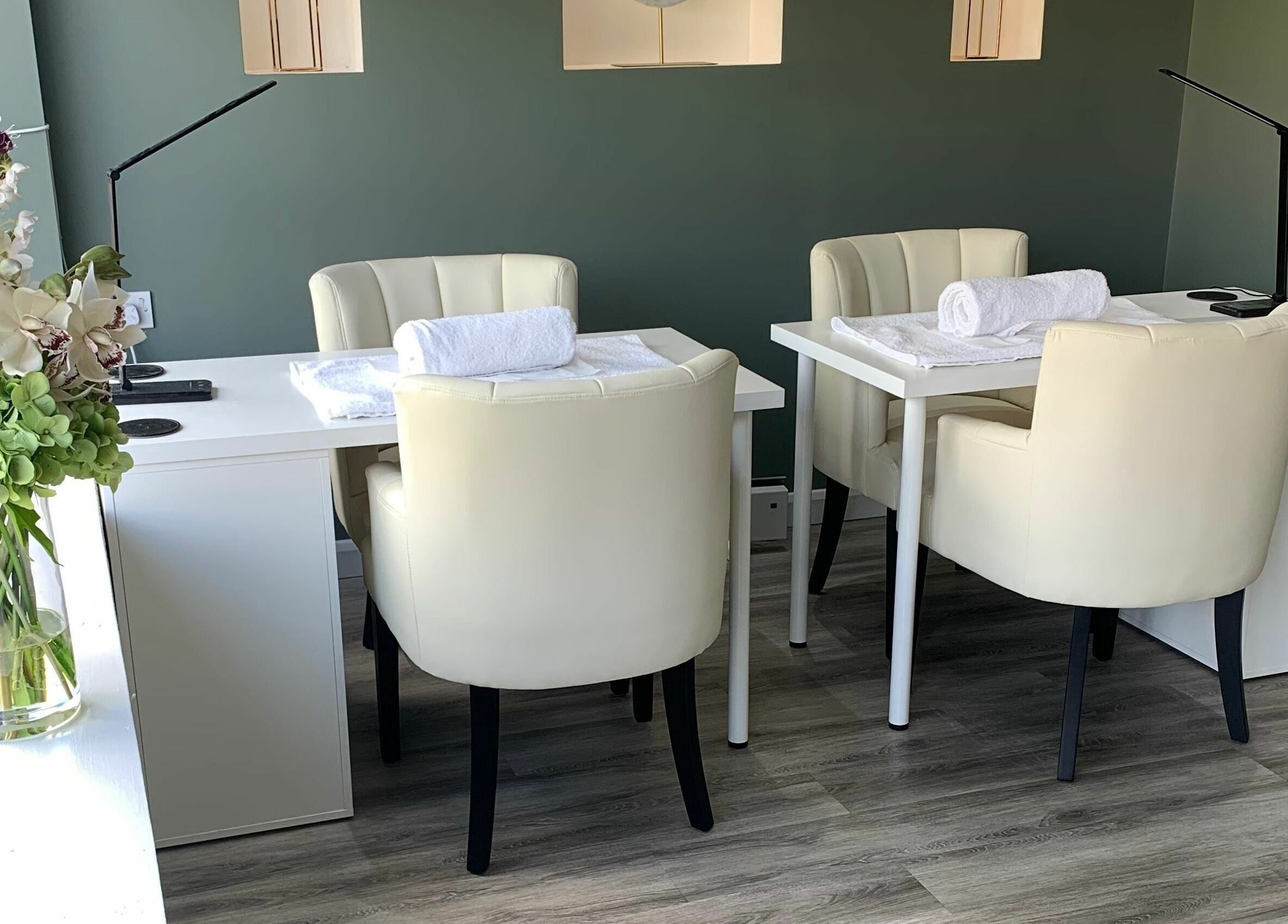 Elegant nail salon setup at Harmony, Brentwood, England, GB with cozy chairs and fresh flowers.