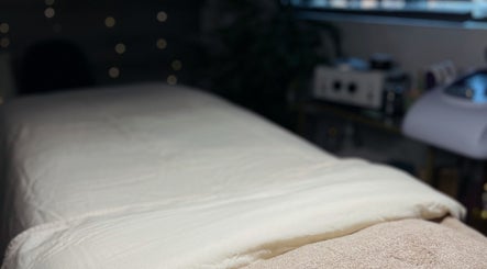 Cozy massage table at Mnmlsm Beauty in Toronto, Ontario, CA, featuring soft ambient lighting.