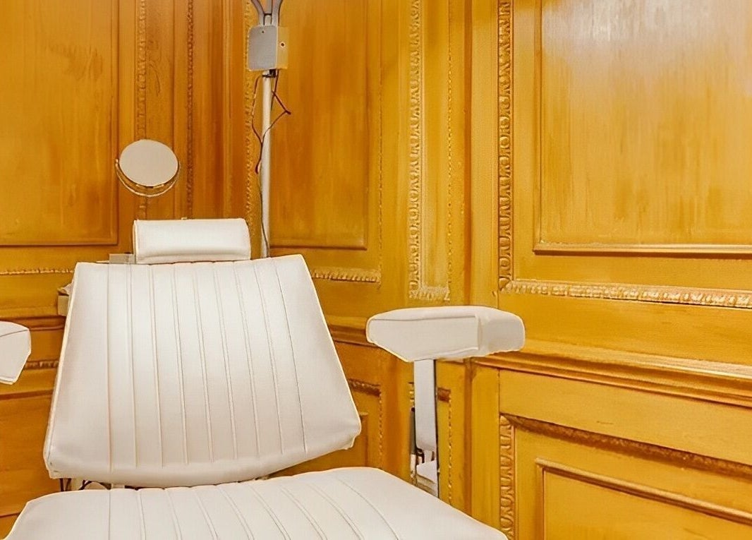 Luxurious white beauty chair at The Nail Station in London, England, GB with elegant wooden paneling.
