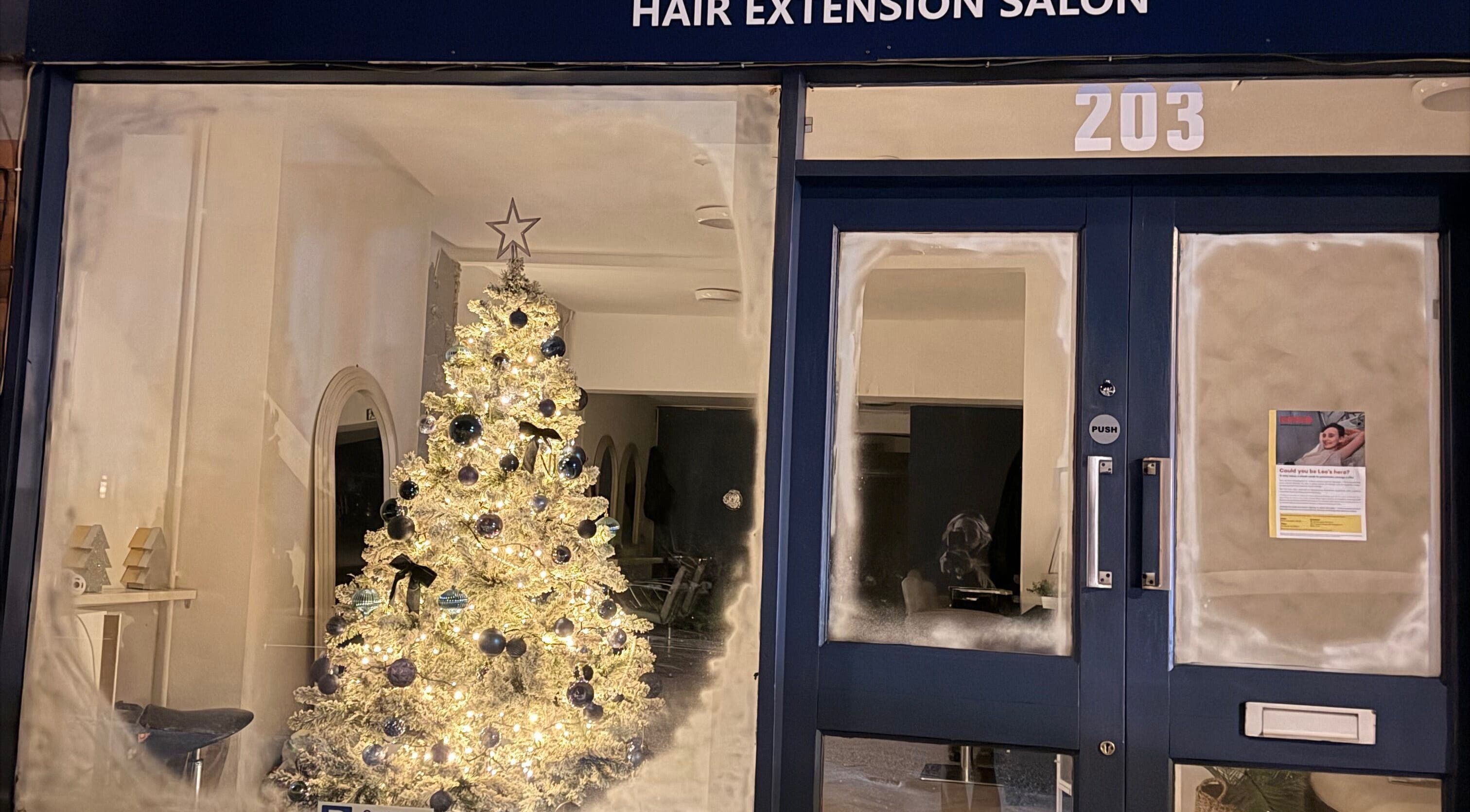 Bella Melenas in Bromsgrove, England, with a festive Christmas tree and cozy salon ambiance.