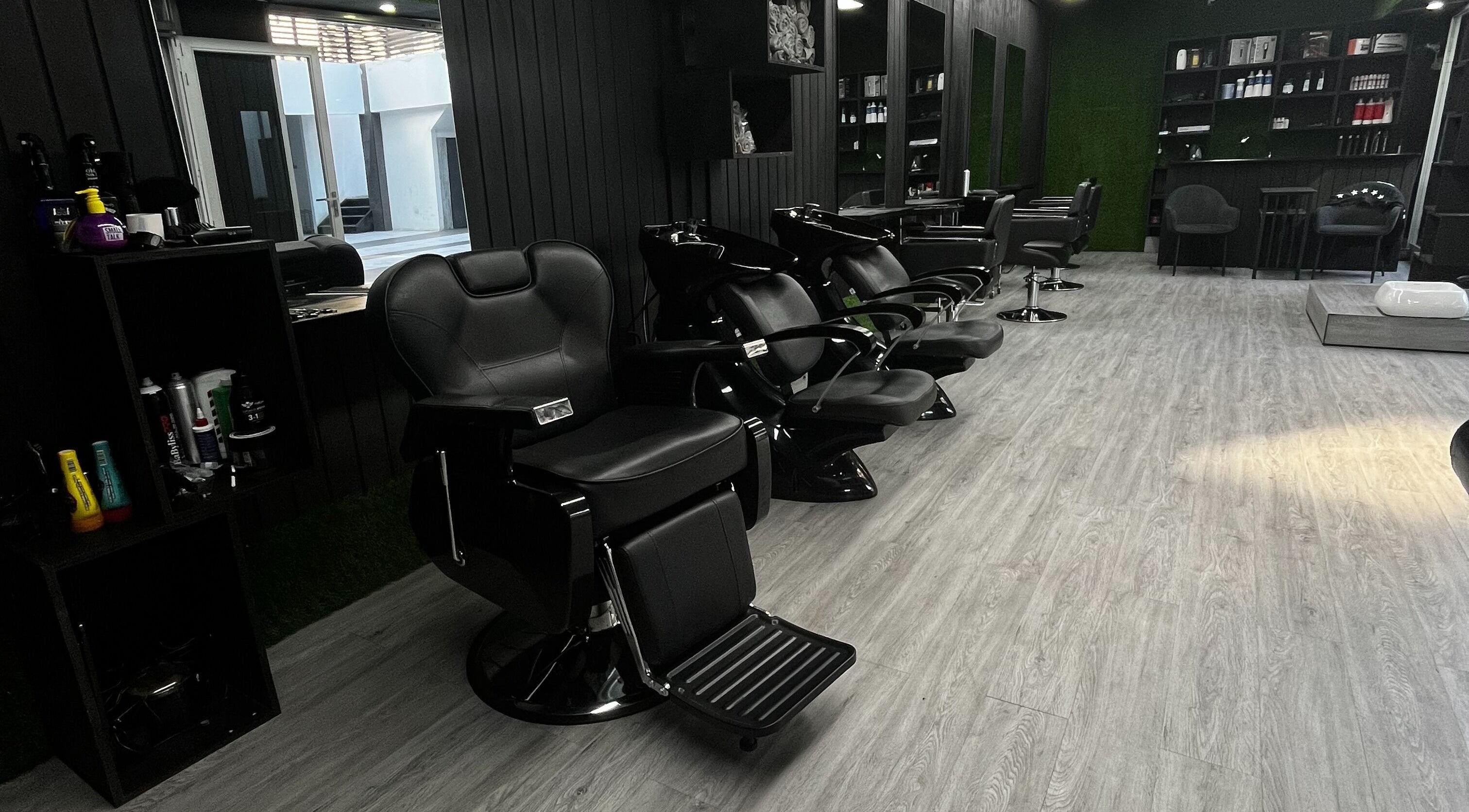 Moderno interior del Ramy Roukoz Salon en Iquique, Tarapacá, CL con elegantes sillas negras para clientes.