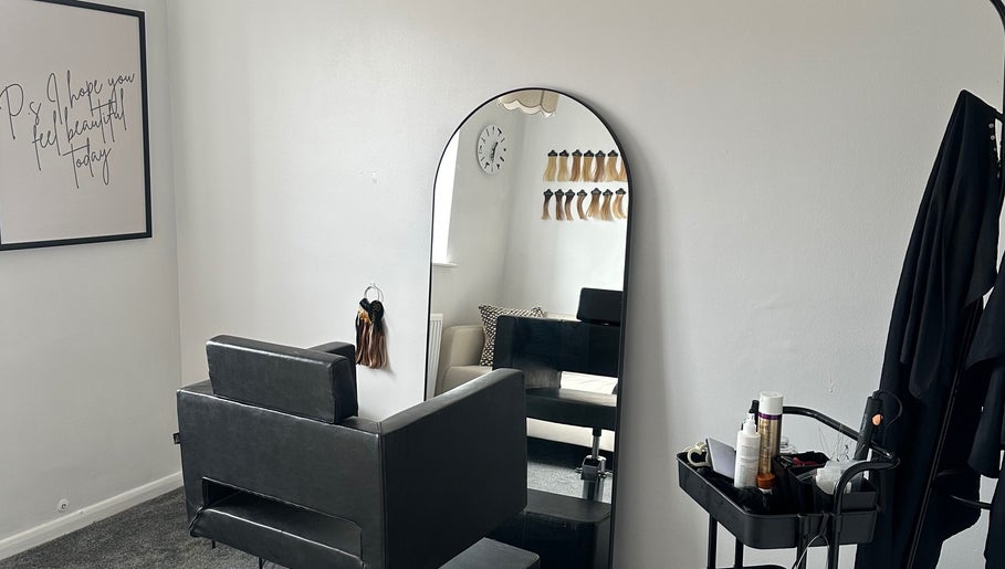 Elegant salon styling chair and mirror at Hair By Ayesha, Daventry, England, GB with hair extensions on display.
