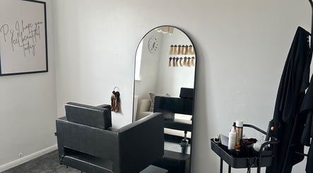 Elegant salon styling chair and mirror at Hair By Ayesha, Daventry, England, GB with hair extensions on display.