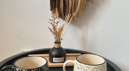 Comforting salon setup at Hair By Ayesha in Daventry, England, GB, featuring decorative mugs and a diffuser.