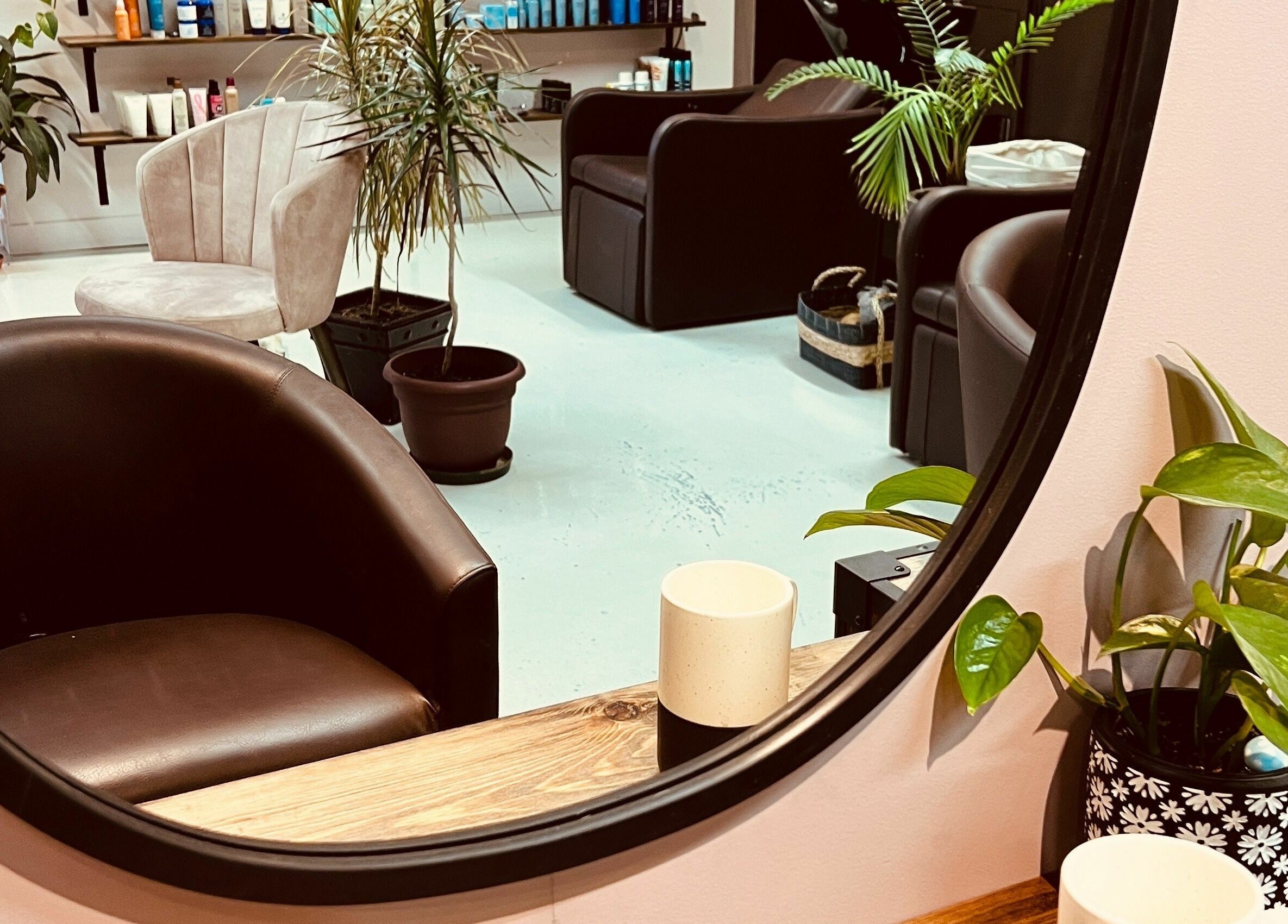 Interior view of Botega Salon and Gallery, Banff, Alberta, CA with stylish seating and plants.