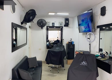 Interior moderno de Jg Barbería en Cali, Valle Del Cauca, CO con espejo y sillas elegantes.