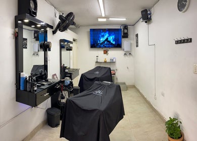 Interior moderno de Jg Barbería en Cali, Valle Del Cauca, CO con sillas de peluquería y decoración elegante.