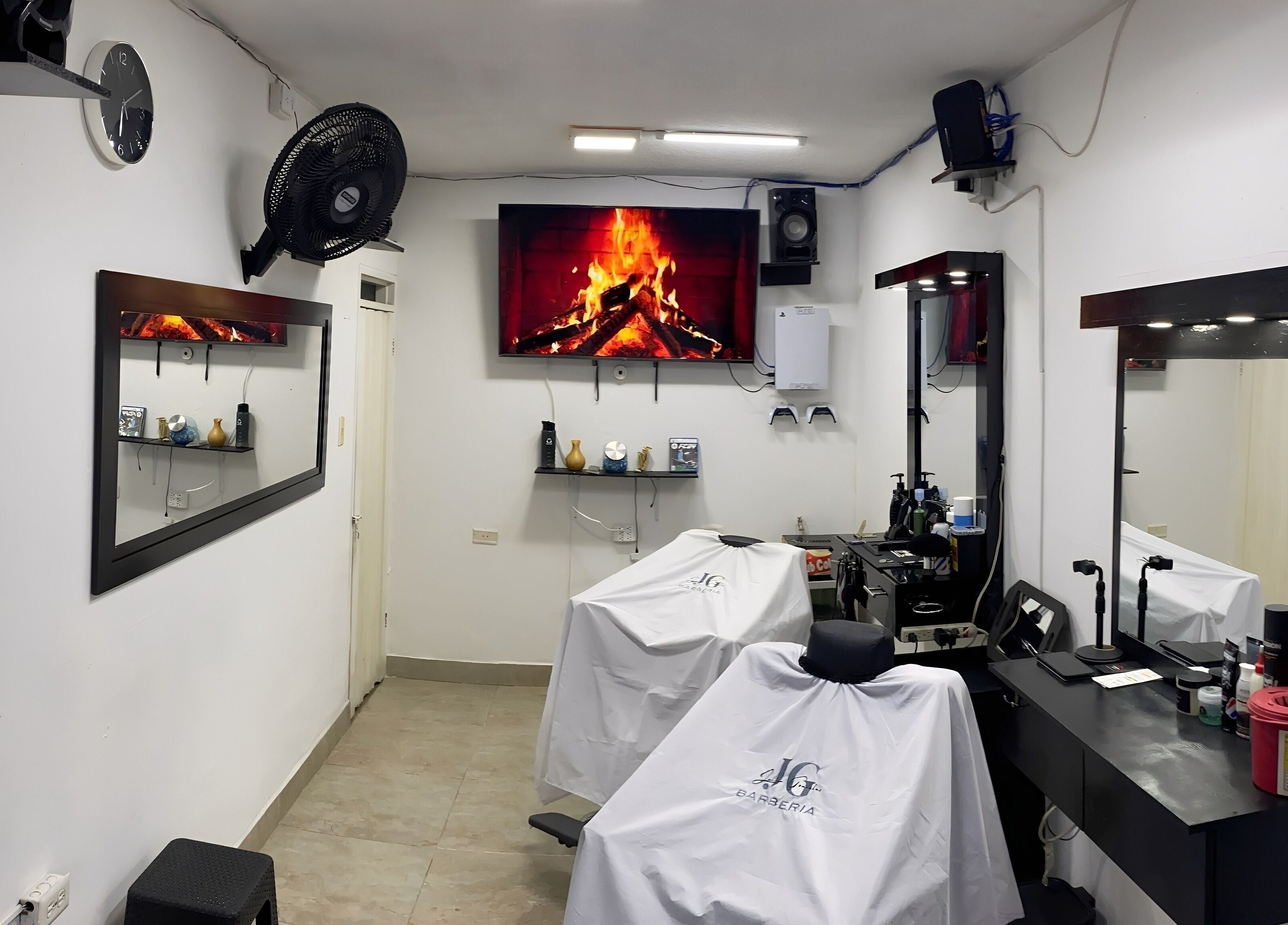Interior moderno de Jg Barbería en Cali, Valle Del Cauca, CO, con sillas elegantes y pantalla con chimenea.