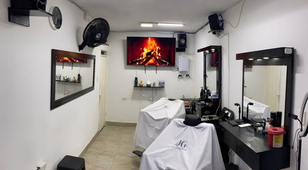 Interior moderno de Jg Barbería en Cali, Valle Del Cauca, CO, con sillas elegantes y pantalla con chimenea.