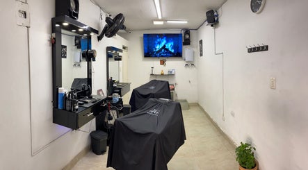 Interior moderno de Jg Barbería en Cali, Valle Del Cauca, CO, con estaciones de trabajo y pantalla.
