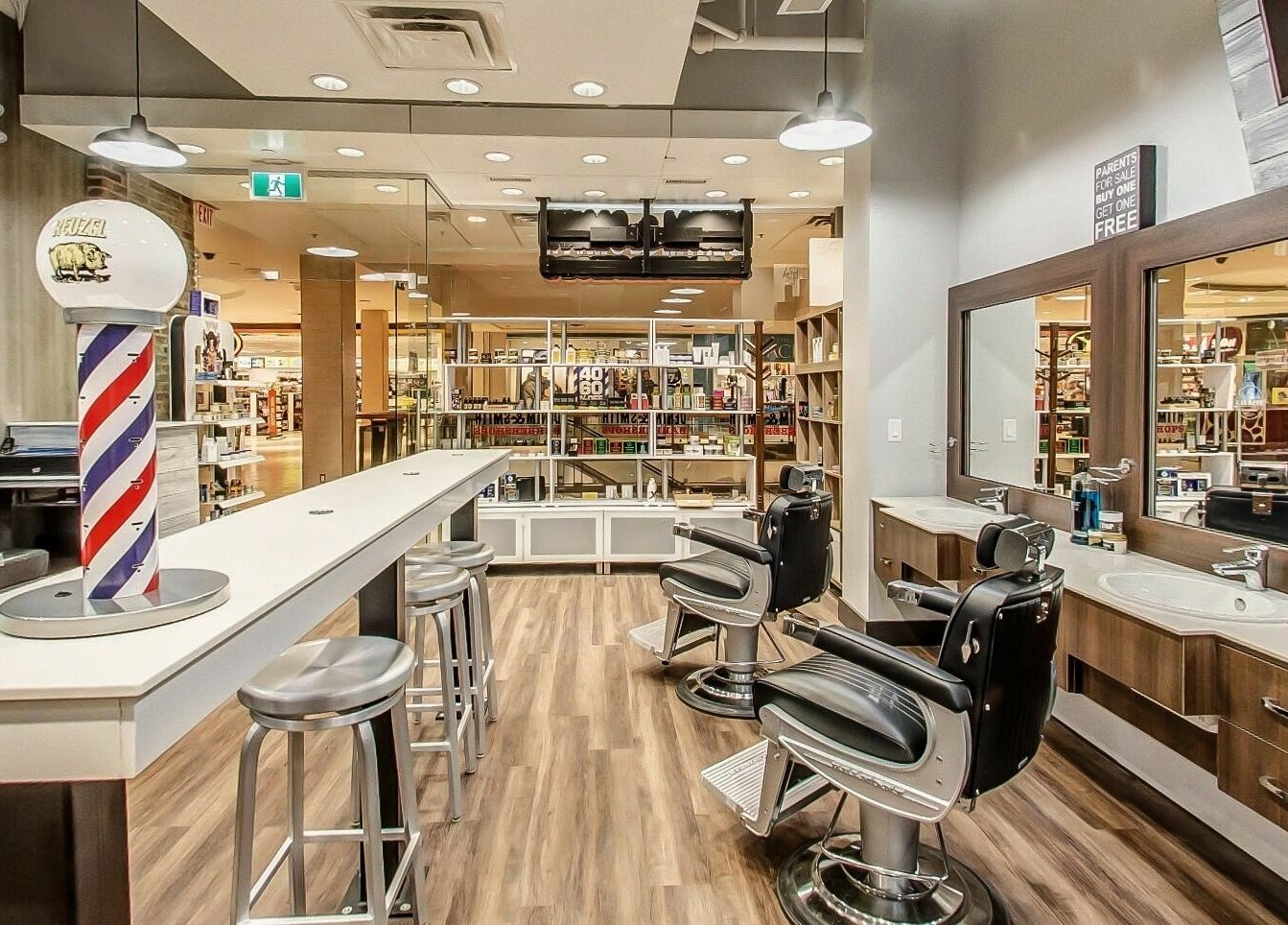 Modern interior of Denim and Smith Barbershop Chinook in Calgary, Alberta, CA with chairs and barber pole.
