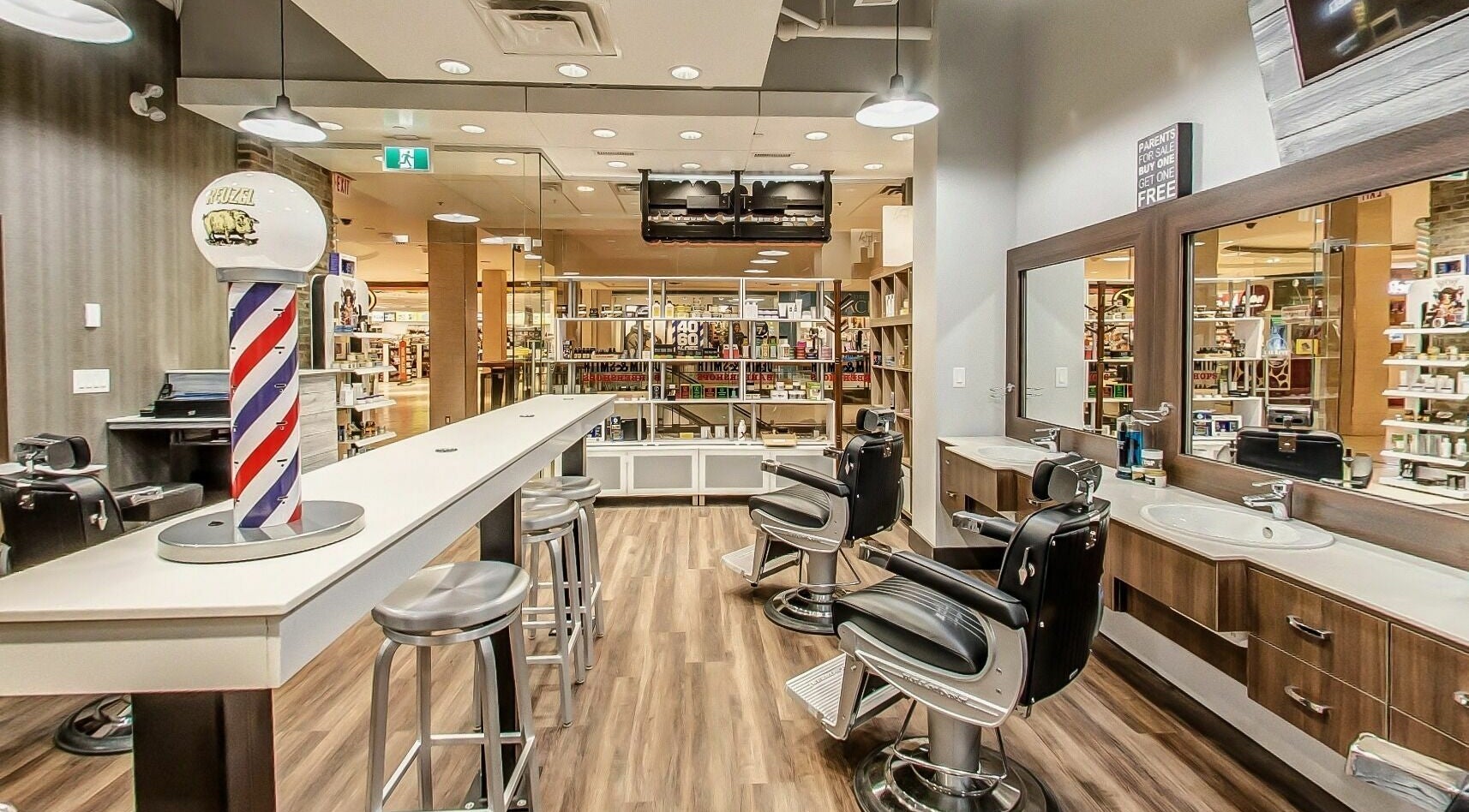 Modern interior of Denim and Smith Barbershop Chinook in Calgary, Alberta, CA with chairs and barber pole.