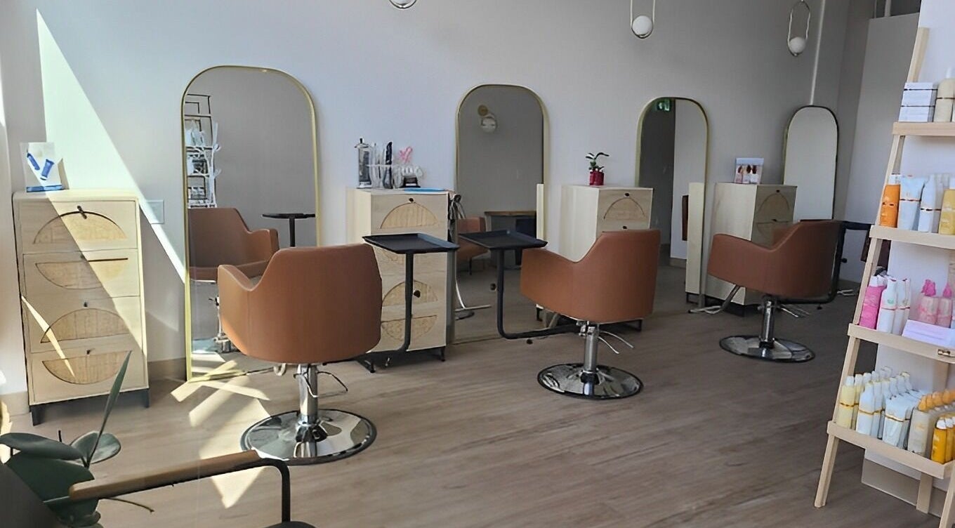 Sleek interior of Blondie Hair Bar in Winnipeg, Manitoba, CA with modern salon chairs and mirrors.