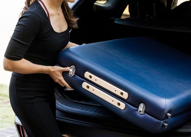 Woman removing massage table from car at Eden By Eva, Brisbane, Queensland, AU.