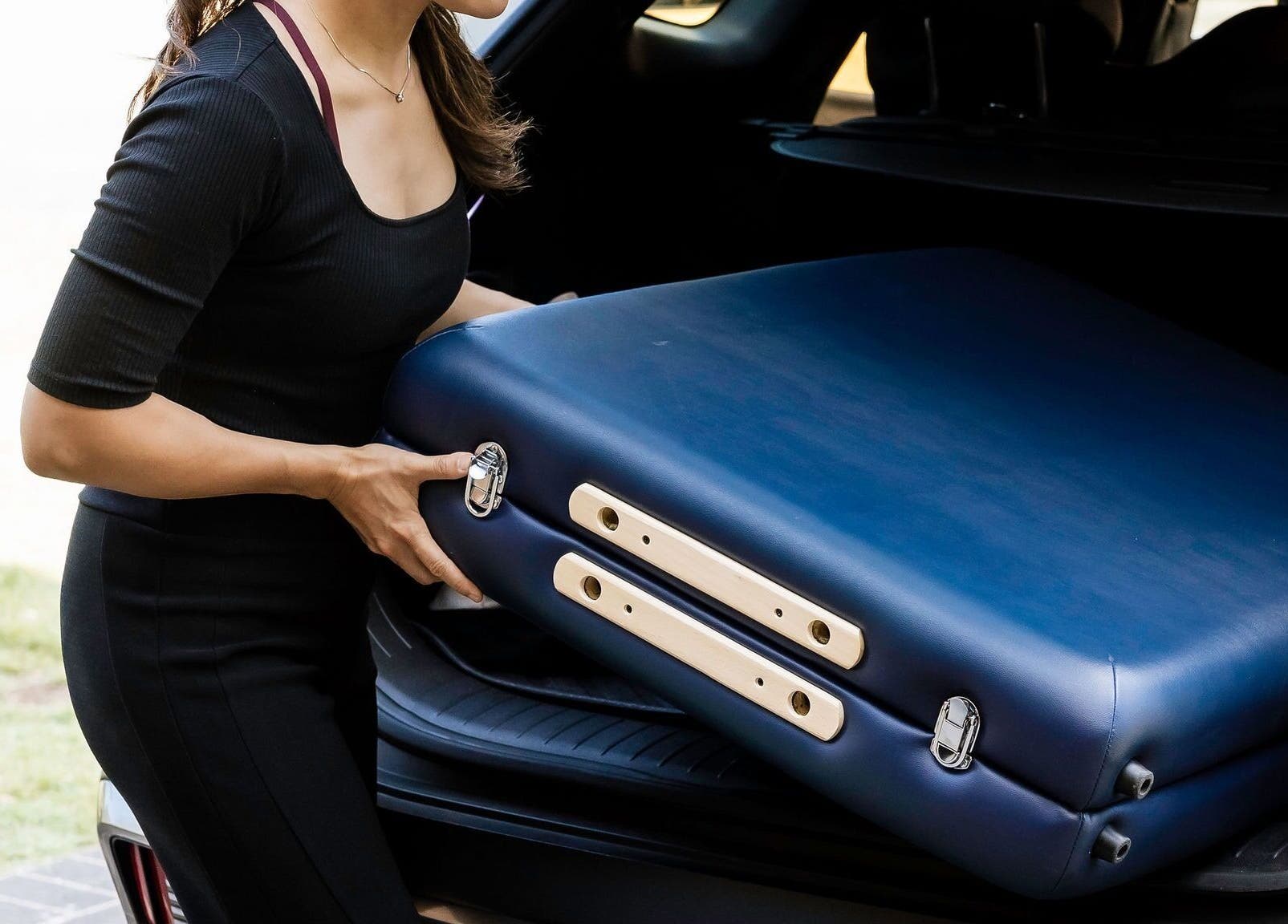 Woman removing massage table from car at Eden By Eva, Brisbane, Queensland, AU.