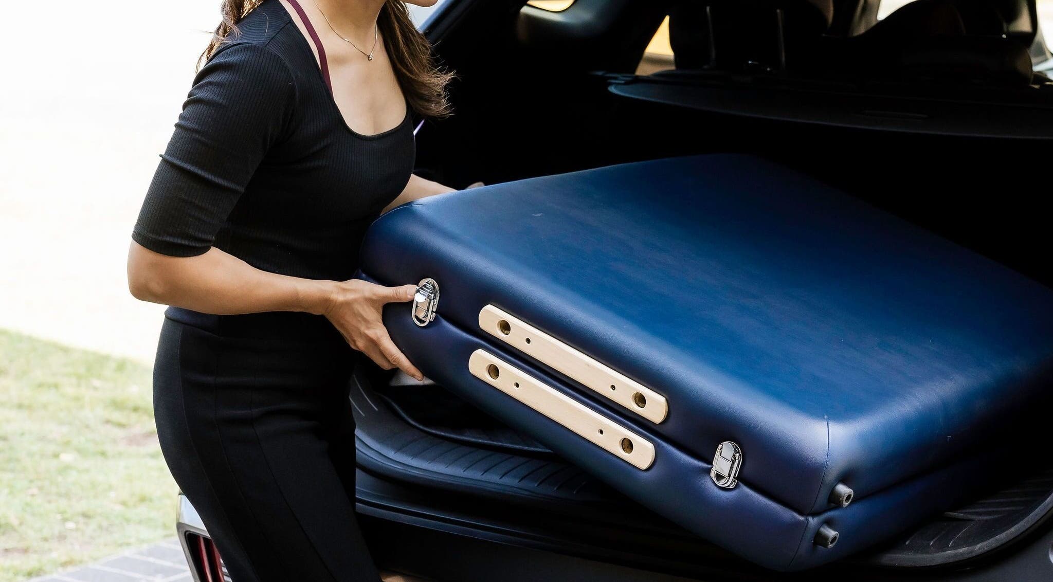 Woman removing massage table from car at Eden By Eva, Brisbane, Queensland, AU.