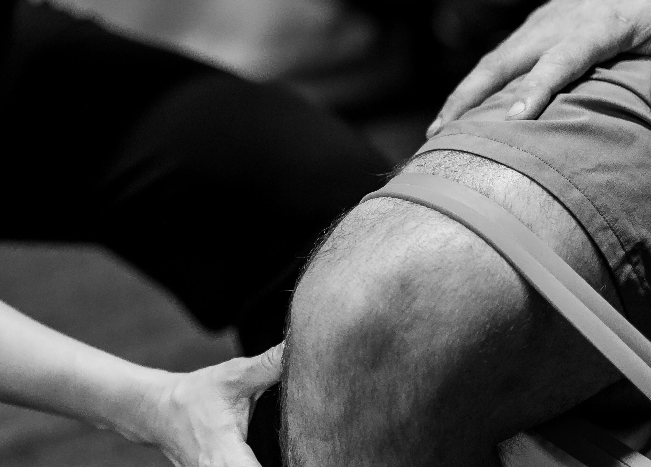 Physical therapy session at Eden By Eva, Brisbane, Queensland, AU. Close-up of knee with resistance band.