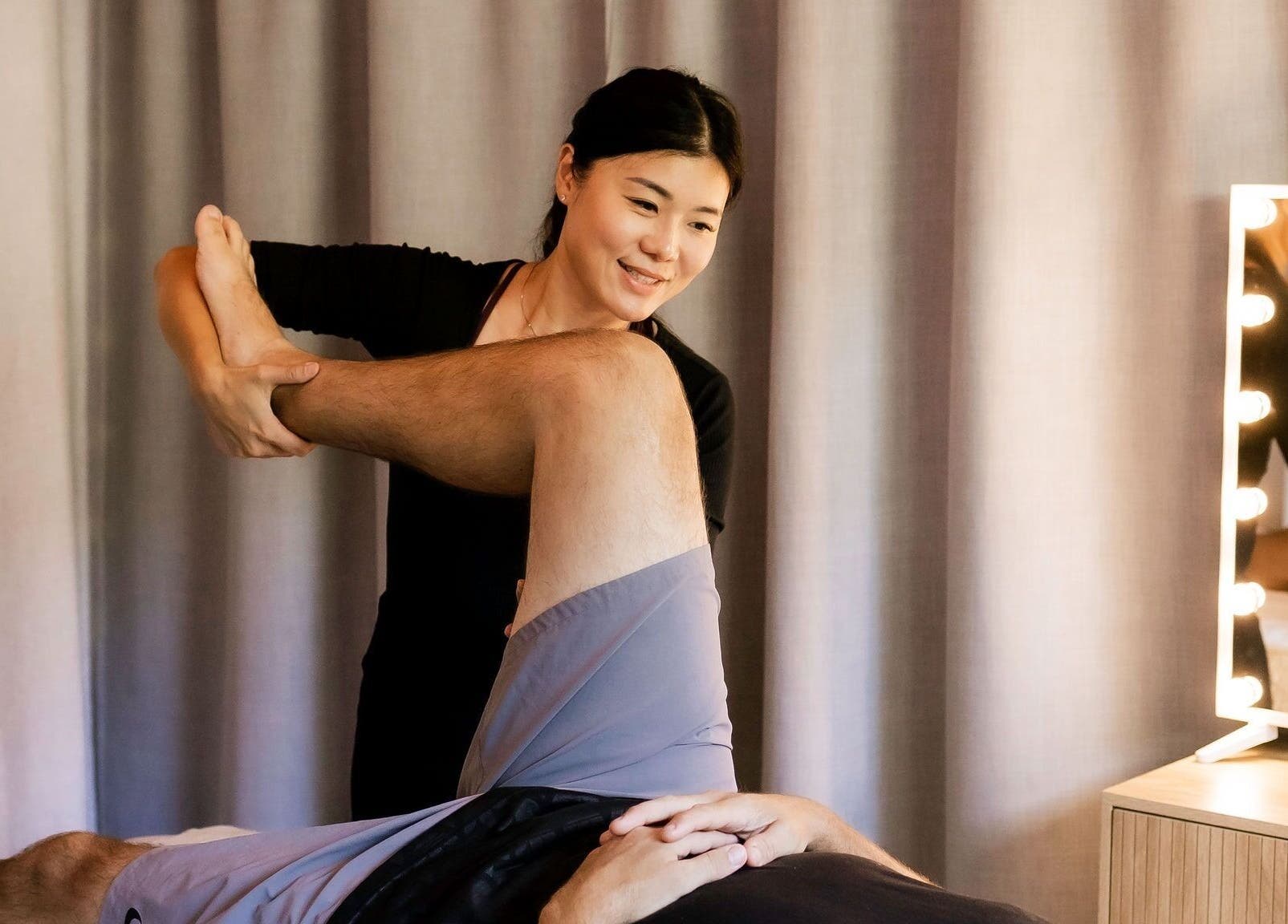Massage therapist at Eden By Eva in Brisbane, Queensland, AU providing a relaxing leg treatment.