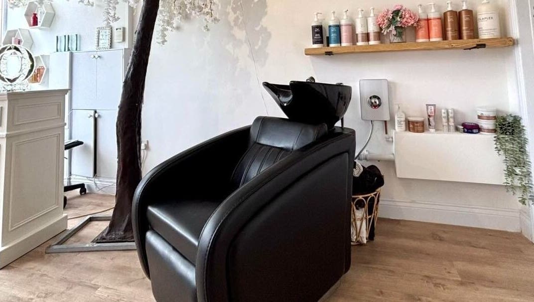 Euphoria Hairdressing in Bath, England, GB features a stylish black salon chair with premium hair products displayed.