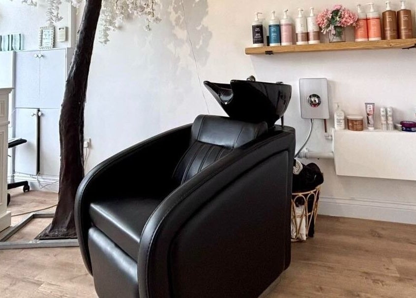 Euphoria Hairdressing in Bath, England, GB features a stylish black salon chair with premium hair products displayed.