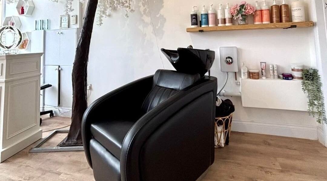Euphoria Hairdressing in Bath, England, GB features a stylish black salon chair with premium hair products displayed.