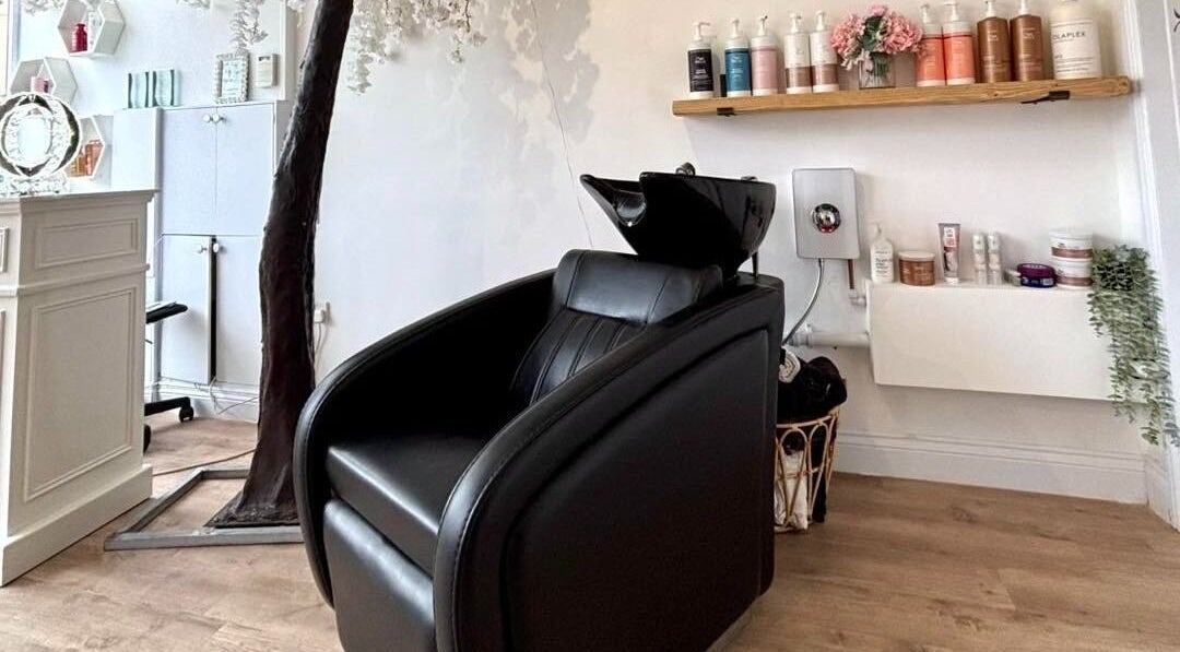 Euphoria Hairdressing in Bath, England, GB features a stylish black salon chair with premium hair products displayed.