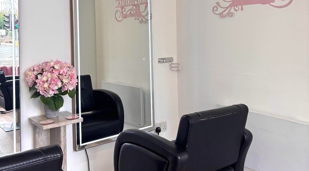 Elegant interior of Euphoria Hairdressing in Bath, England, GB with plush chair and floral decor.