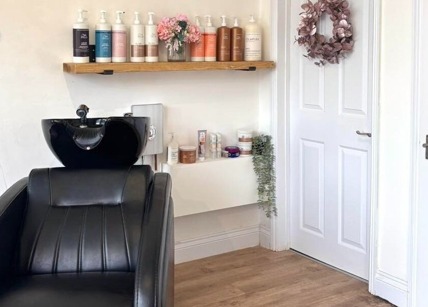 Euphoria Hairdressing's stylish salon corner in Bath, England, GB with shampoo bottles and a sleek chair.