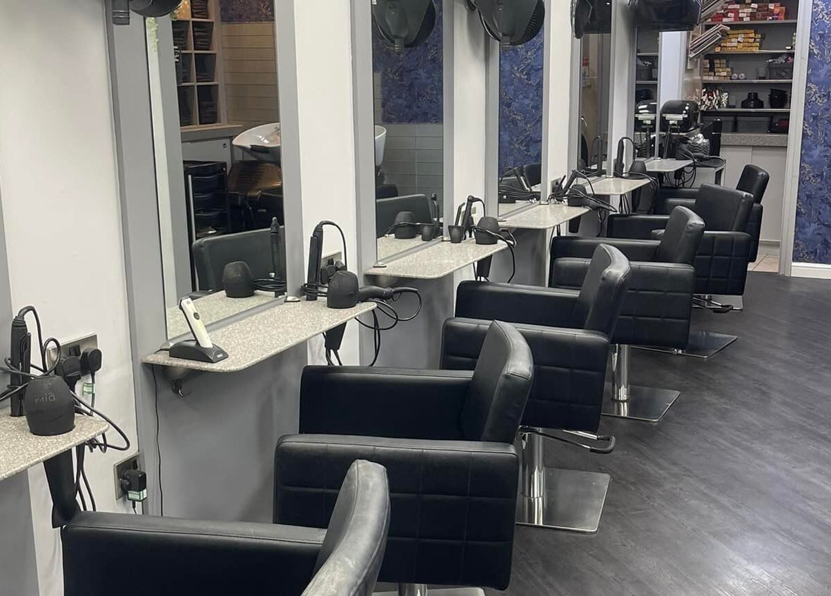 Modern salon interior at Hairtek, Yarm, England, GB with stylish black chairs and sleek mirrors.