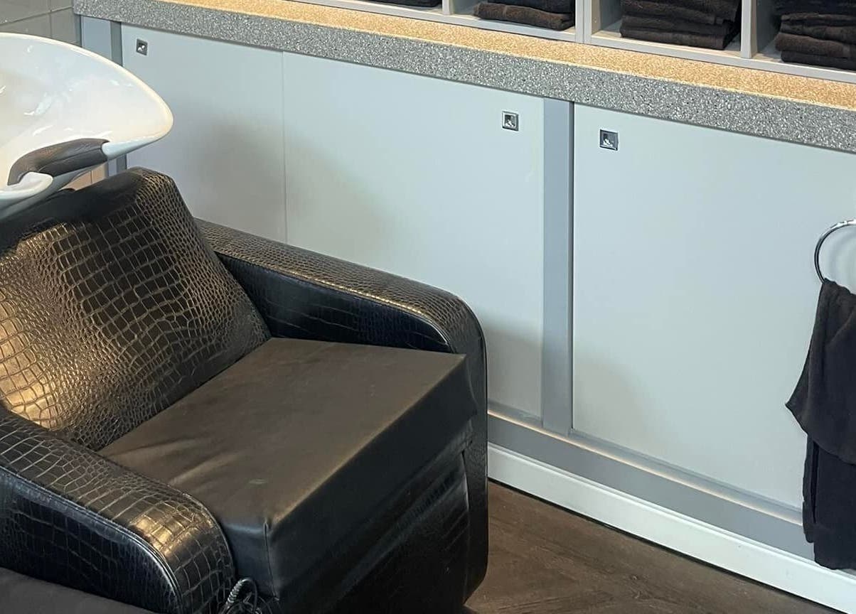 Luxury salon wash station at Hairtek, Yarm, England, GB, featuring sleek black leather seating.