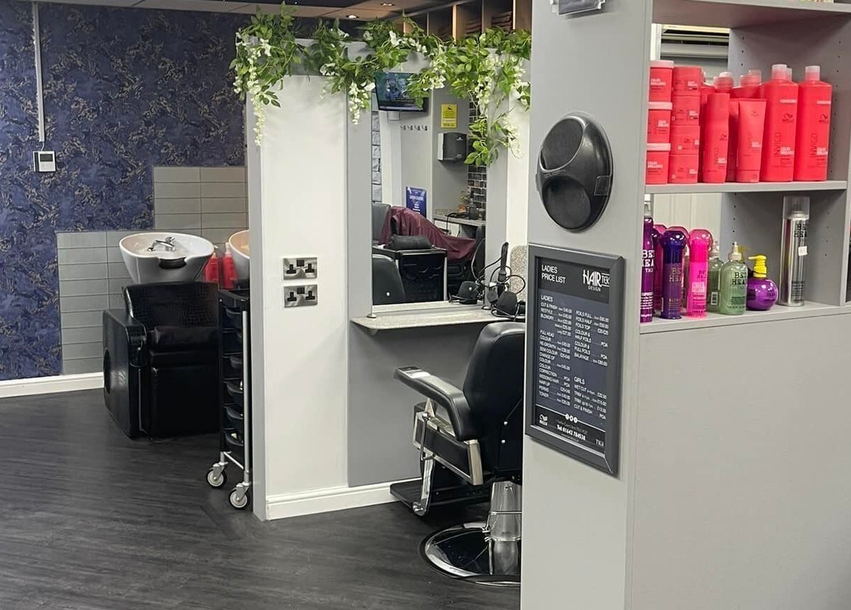 Interior of Hairtek in Yarm, England, GB with black chairs, mirrors, and shelves of hair products.