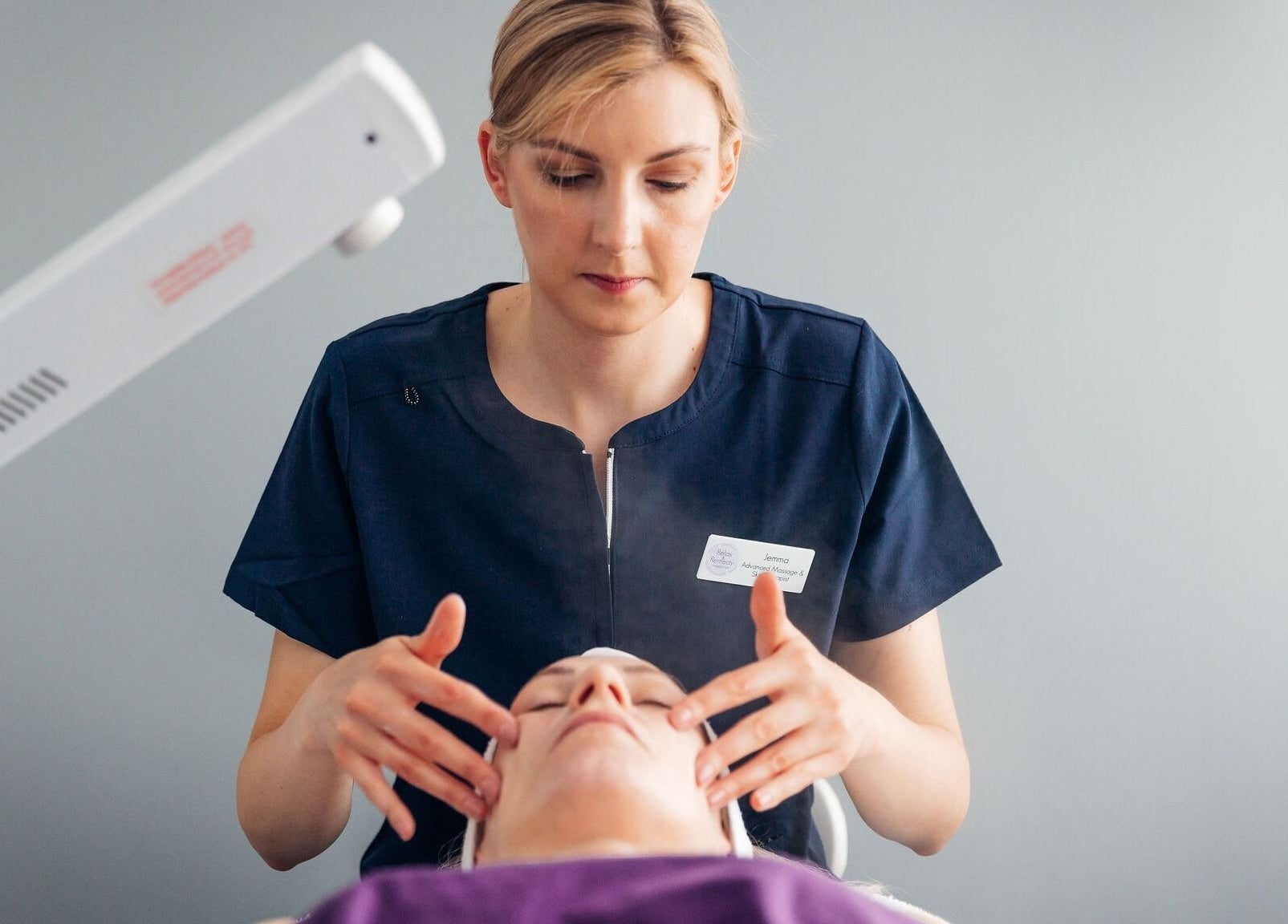 Skilled therapist performing a facial massage at Relax & Remedy, Ferndown, England, GB.