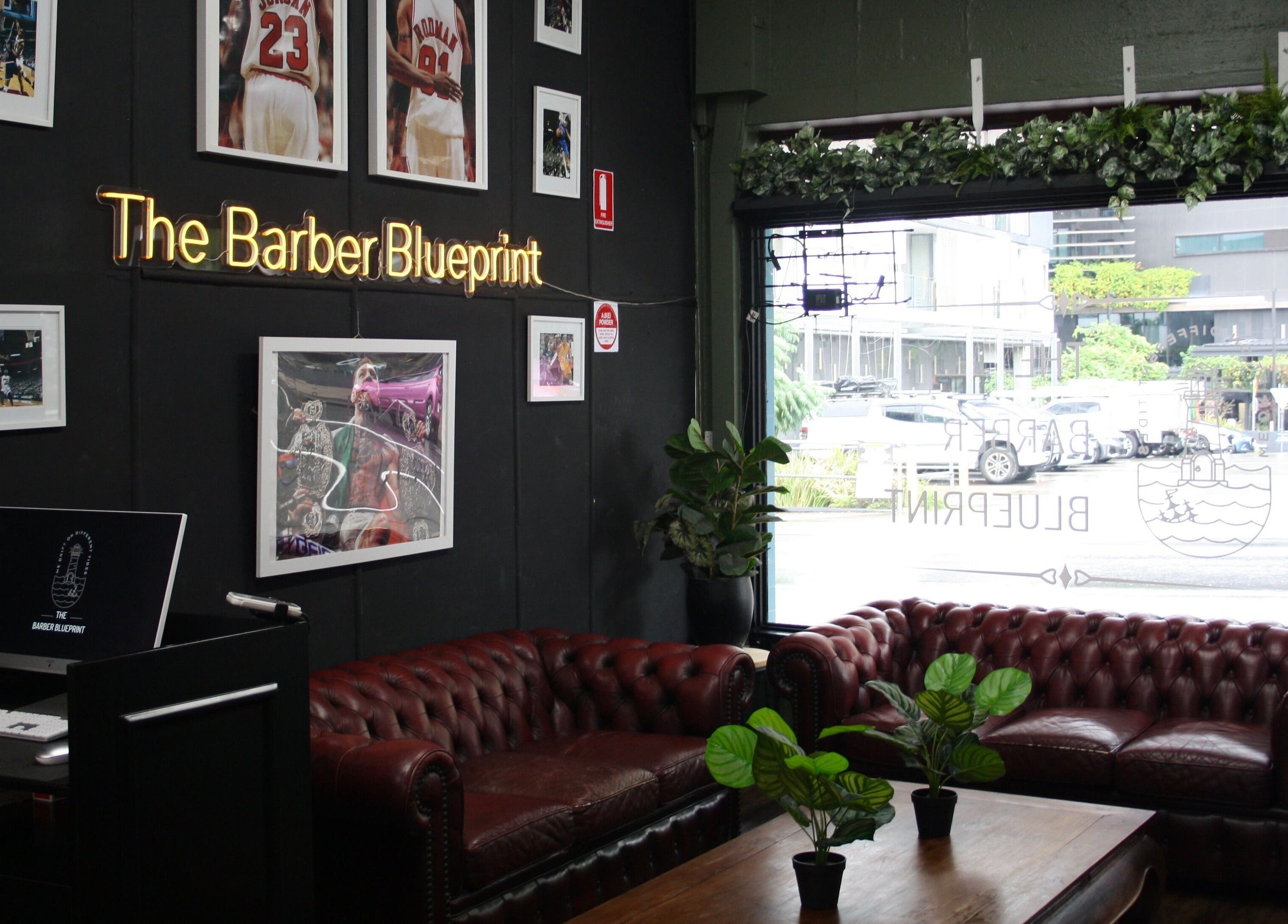 Elegant lounge area at The Barber Blueprint, Nundah, Queensland, AU, featuring leather sofas and stylish decor.